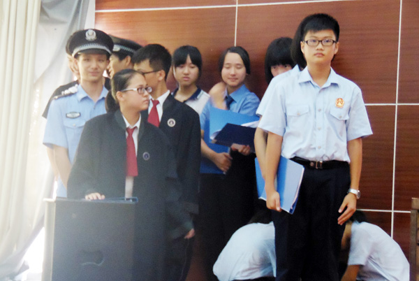 "书记员","辩护人","公诉人"身着检察官制服,法官袍,法警制服,站在